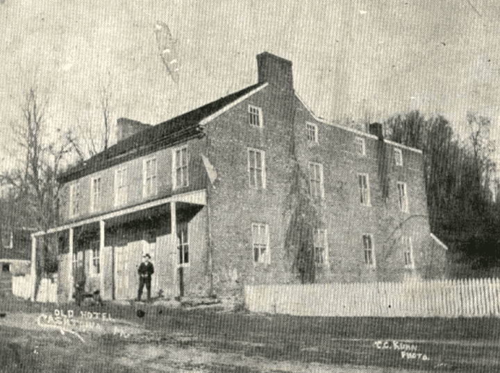 Historic black-and-white photo of the Old Hotel in Cashtown, with a man standing in front.